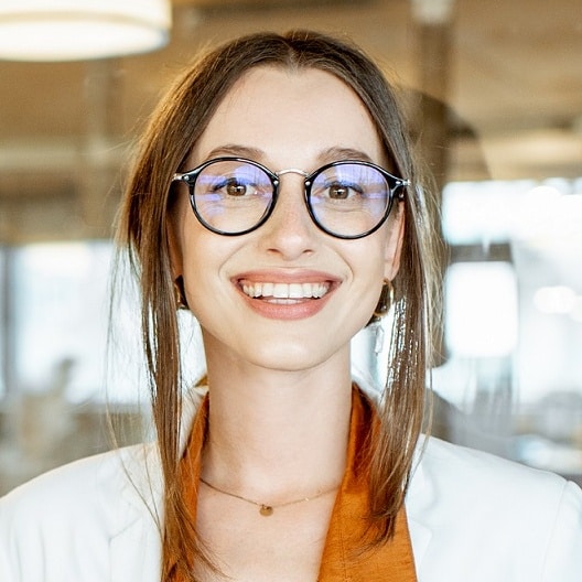 portrait d'une femme les cheveux attachés qui sourit